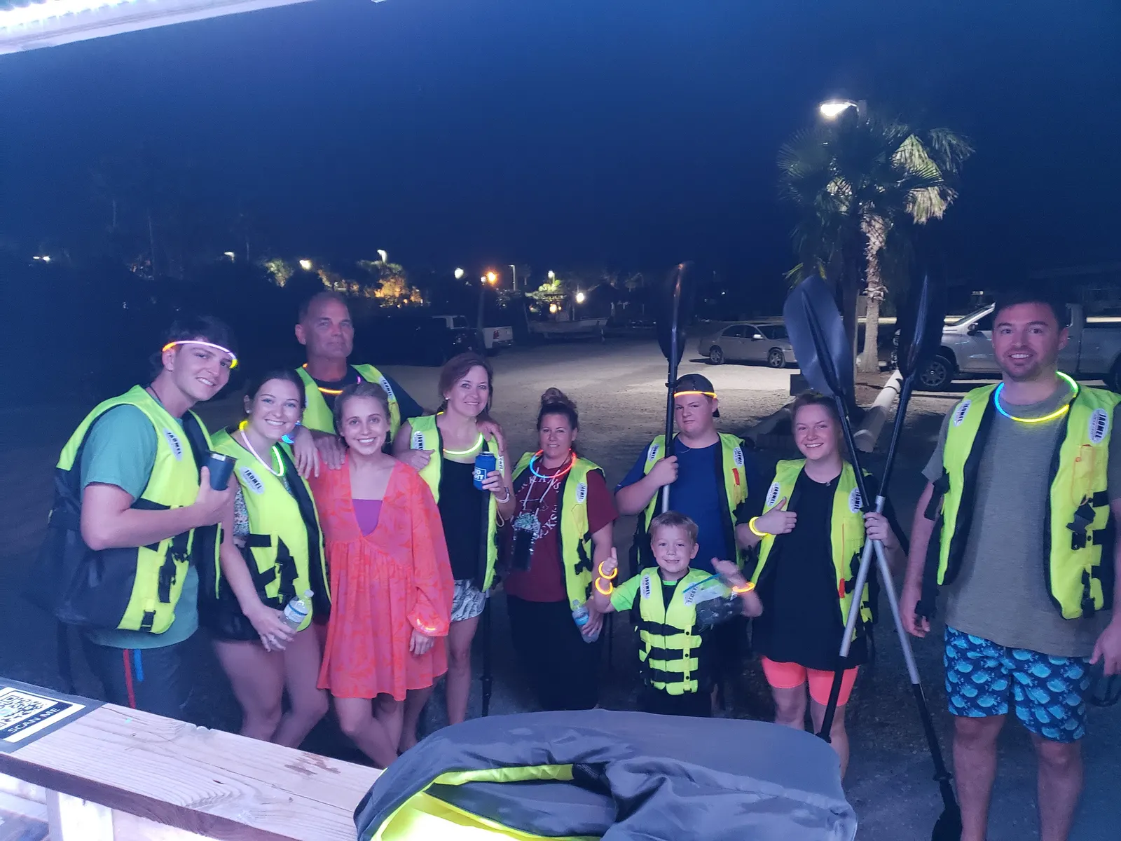 A group of guests wearing glow necklaces and life jackets before a Sea View Tours night glow kayak tour
